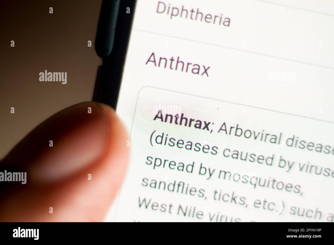 Anthrax nouvelles sur le téléphone.téléphone mobile en mains. Mise au point sélective et aberrations chromatiques. Banque D'Images