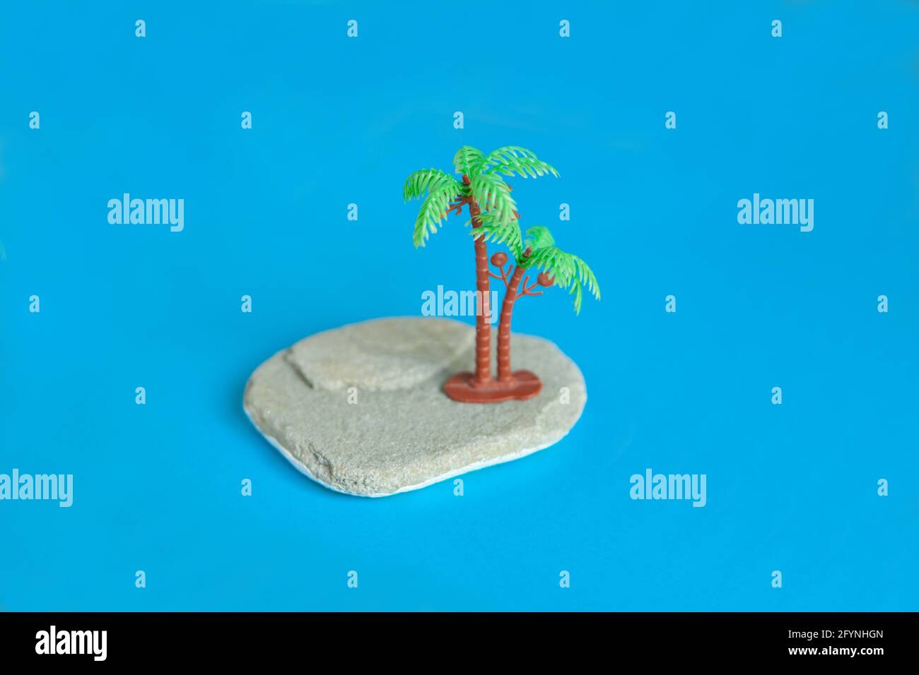 Miniature image plastique jouets à la plage - jouet palmtree sur la pierre à papier bleu. Banque D'Images