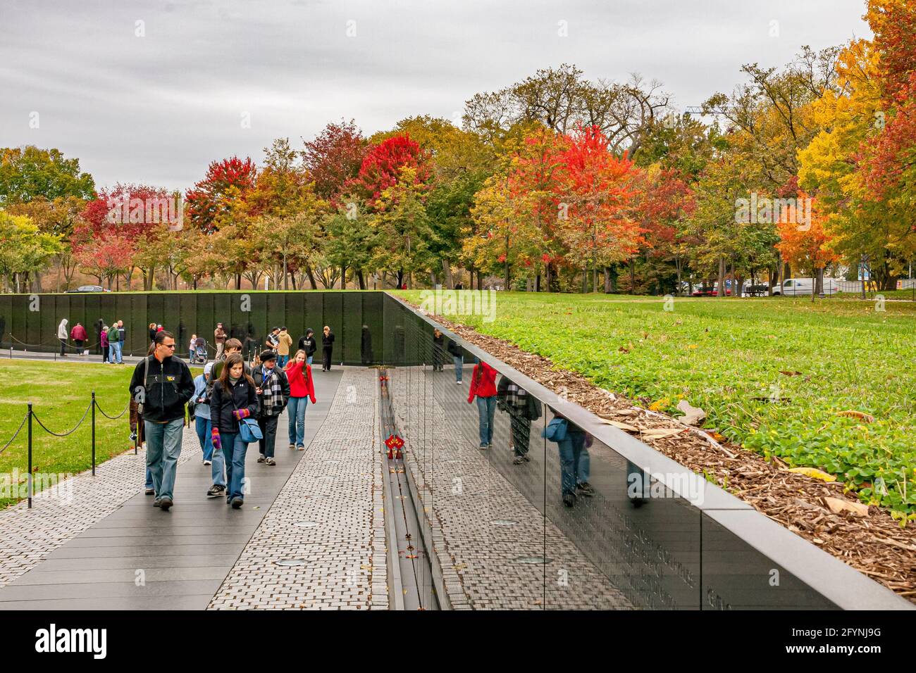 Les personnes qui marchent devant le mur commémoratif des anciens combattants du Vietnam qui rend hommage aux membres des forces armées américaines qui ont combattu pendant la guerre du Vietnam, Washington DC Banque D'Images