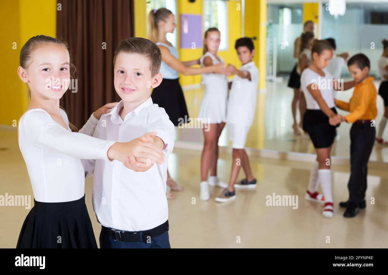 Portrait of smiling children enjoying de danse partenaire en classe Banque D'Images