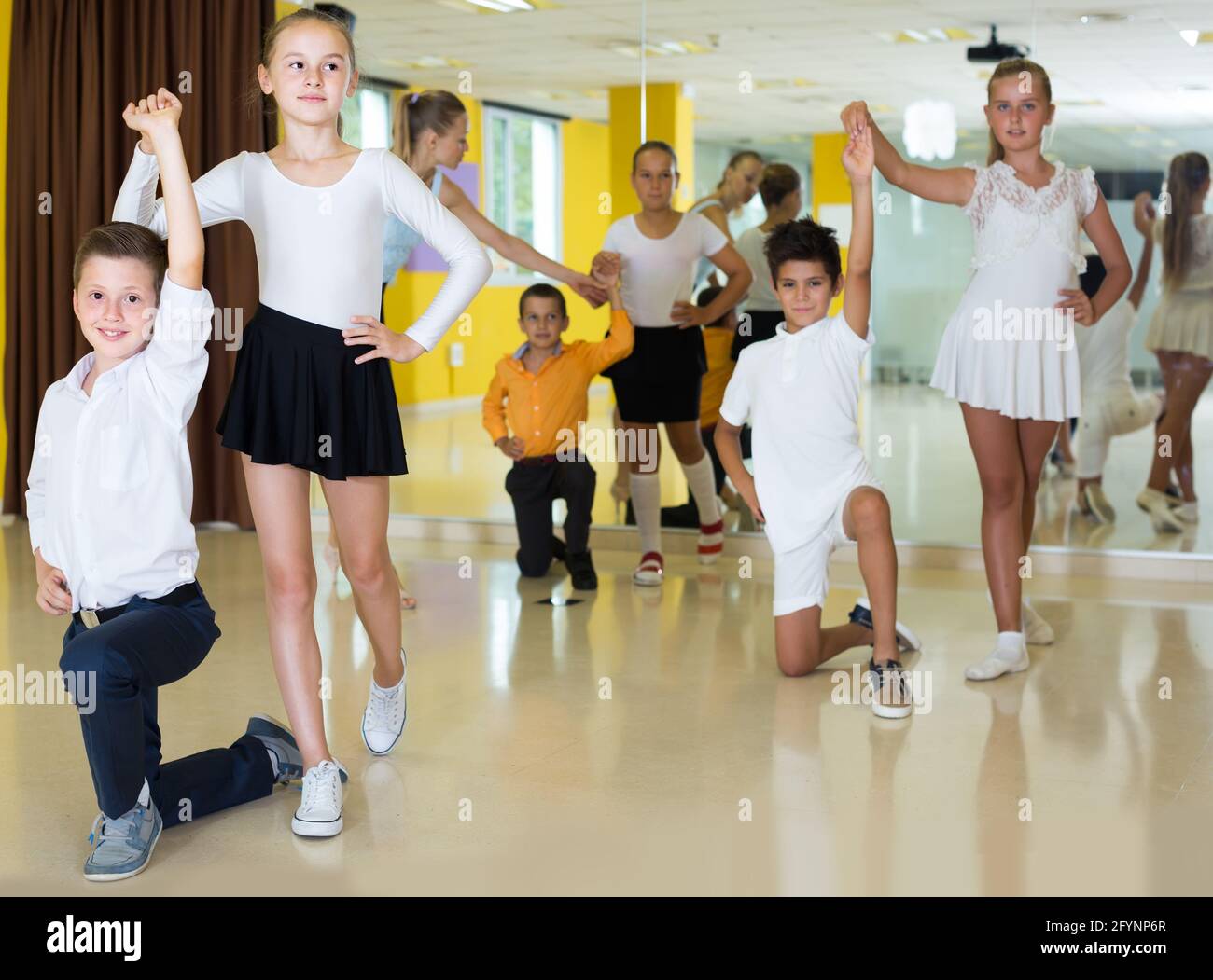 les enfants souriants dansent en couple en classe Banque D'Images