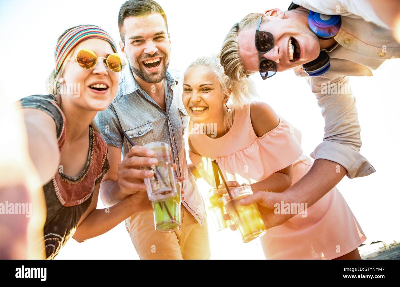 Joyeux groupe d'amis du millénaire prenant le selfie à la fête de plage amusant boire des cocktails au coucher du soleil - joie d'été et amitié concept avec les jeunes Banque D'Images