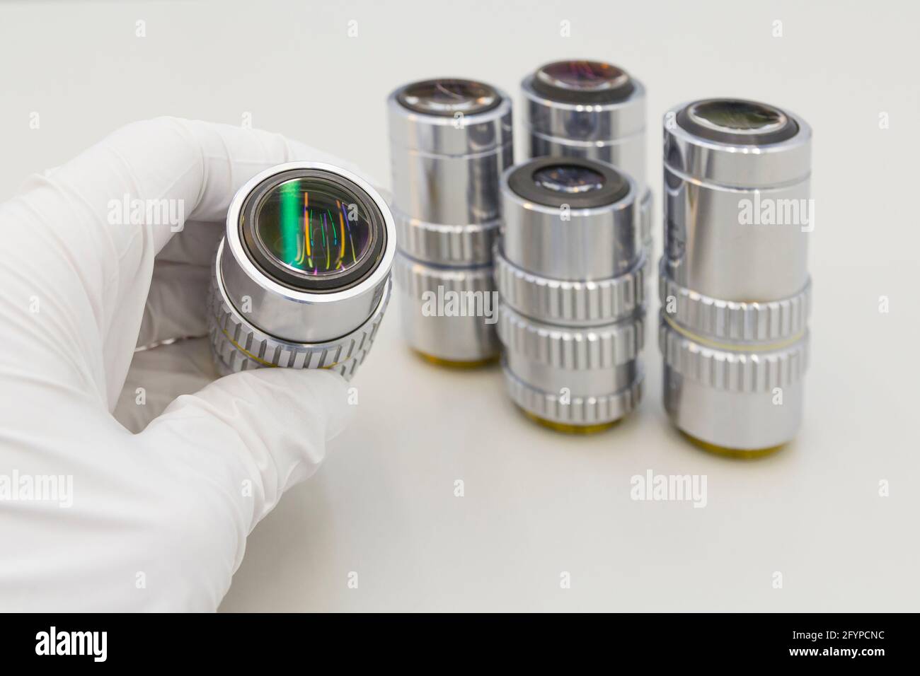 Beaucoup d'objectifs différents de l'agrandissement sur un fond blanc. Gros plan des objectifs du microscope. Banque D'Images