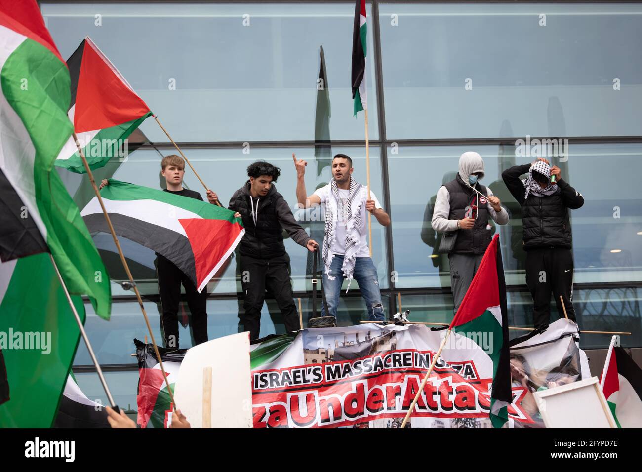 Les manifestants montent la porte des studios de la BBC à Media City, Salford, Greater Manchester, Royaume-Uni. La démonstration a commencé à 12:00 le 29 mai 2021. La manifestation devait montrer son soutien au peuple palestinien et contre la récente escalade du conflit dans la région. En Palestine, le peuple palestinien a été constamment confronté à un barrage israélien à la suite de roquettes tirées de Gaza par le groupe militant au pouvoir du Hamas. Un cessez-le-feu a commencé au début du vendredi 20 mai 2021, mettant fin à 11 jours de combats au cours desquels plus de 250 personnes ont été tuées, la plupart à Gaza. Photo : Gary Roberts/worldwidefeatures.com Banque D'Images