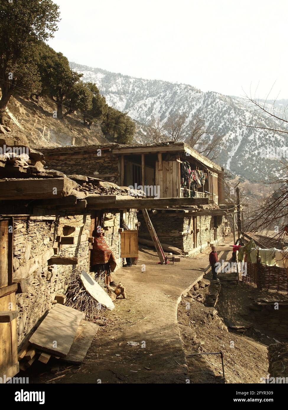 Kalash femme et garçon en robe traditionnelle. Village païen éloigné de Rumbur dans les vallées de Kalasha, Hindu Kush, nord du Pakistan, hiver 2013 Banque D'Images