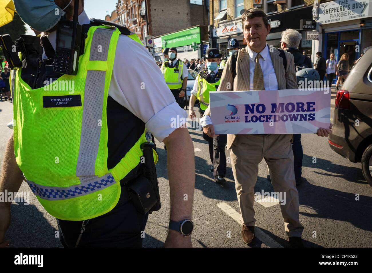 Londres, Royaume-Uni. 29 mai 2021. Un manifestant muni d'un écriteau permet à la police de passer devant lors d'une manifestation anti-verrouillage. Des milliers de personnes sont venues sous la bannière de s'unir pour la paix et leurs droits humains. Le nombre de personnes participant aux manifestations a augmenté mois après mois depuis l'introduction des restrictions COVID-19. Crédit : SOPA Images Limited/Alamy Live News Banque D'Images