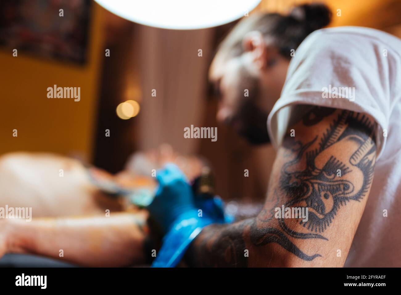 Détail du bras d'un tatouage artiste en travaillant avec un client. Banque D'Images
