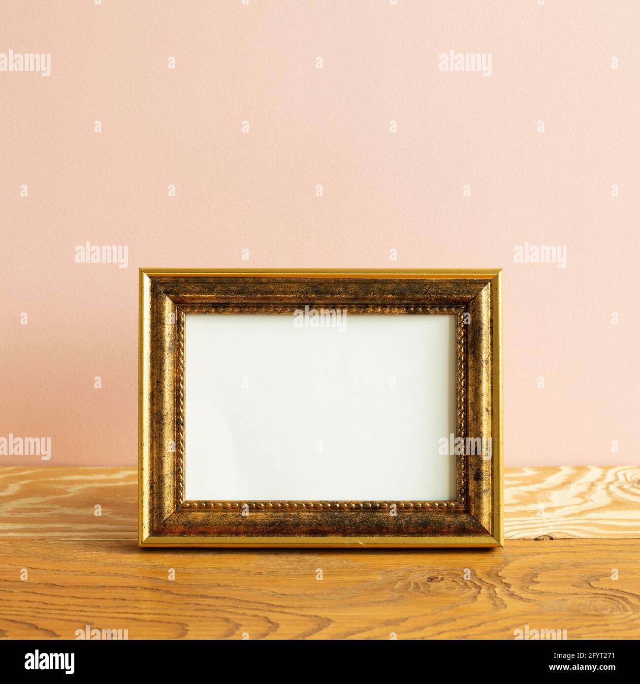 Cadre photo vide sur table en bois. Fond rose Banque D'Images