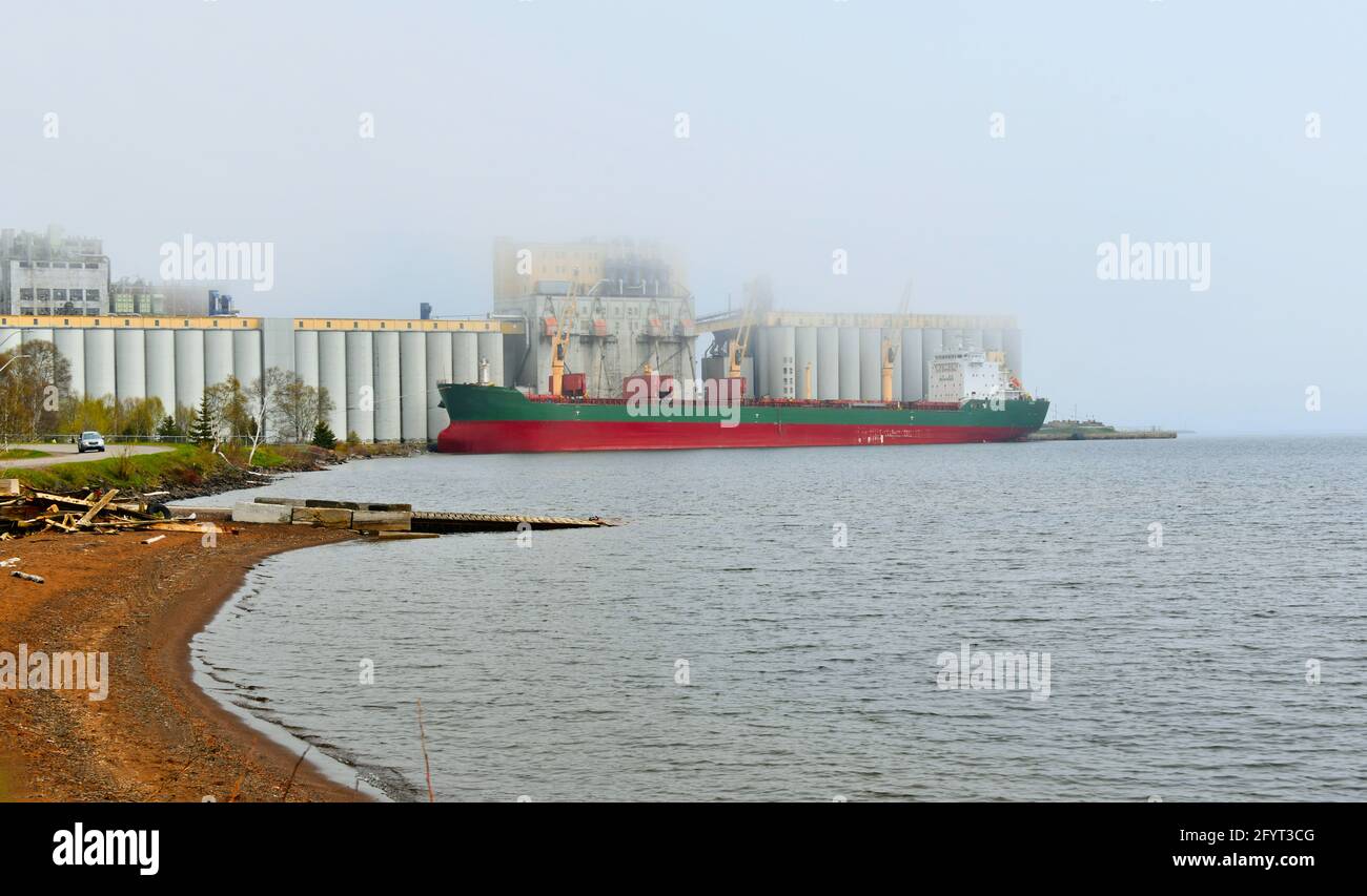 Un navire est en train de charger du grain pour le transport vers les marchés étrangers lors d'une journée de printemps brumeuse à Thunder Bay, Ontario, Canada. Banque D'Images
