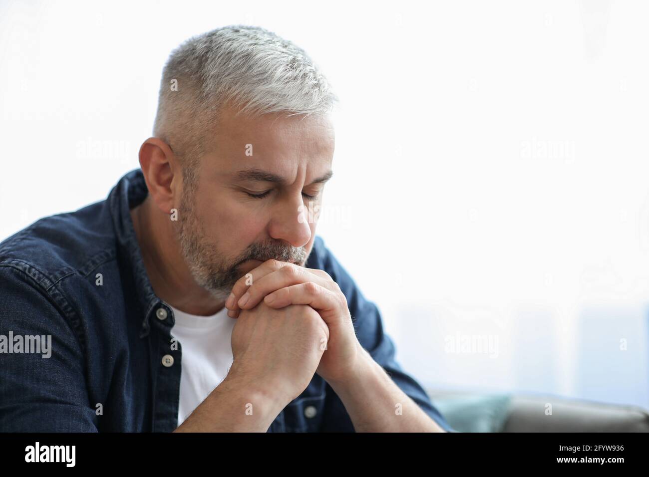 Triste homme âgé se penchait sur les mains, portrait de gros plan Banque D'Images