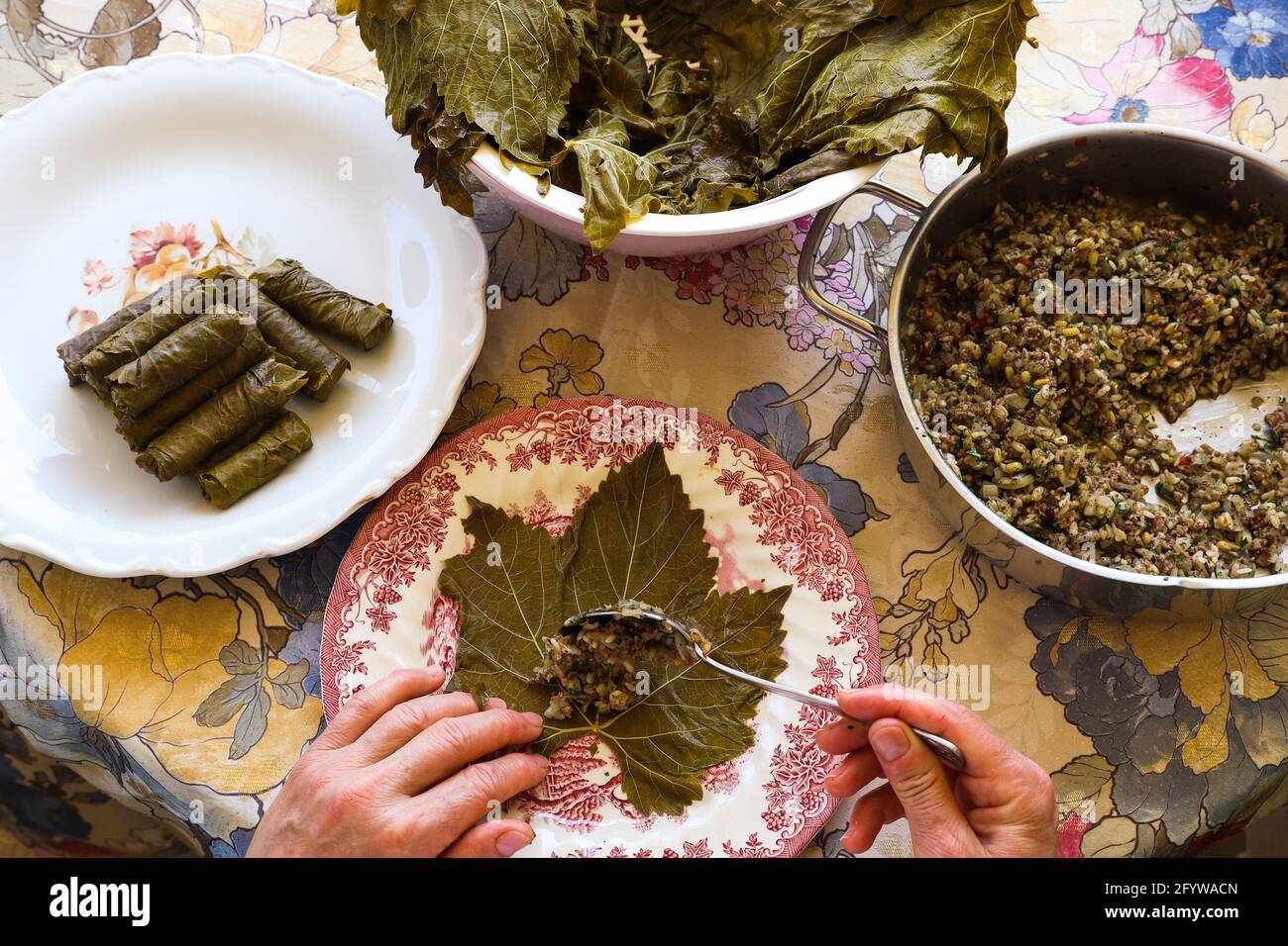 Femme mains, préparer des feuilles de raisin farcies traditionnelles turques et grecques, concept alimentaire. Banque D'Images