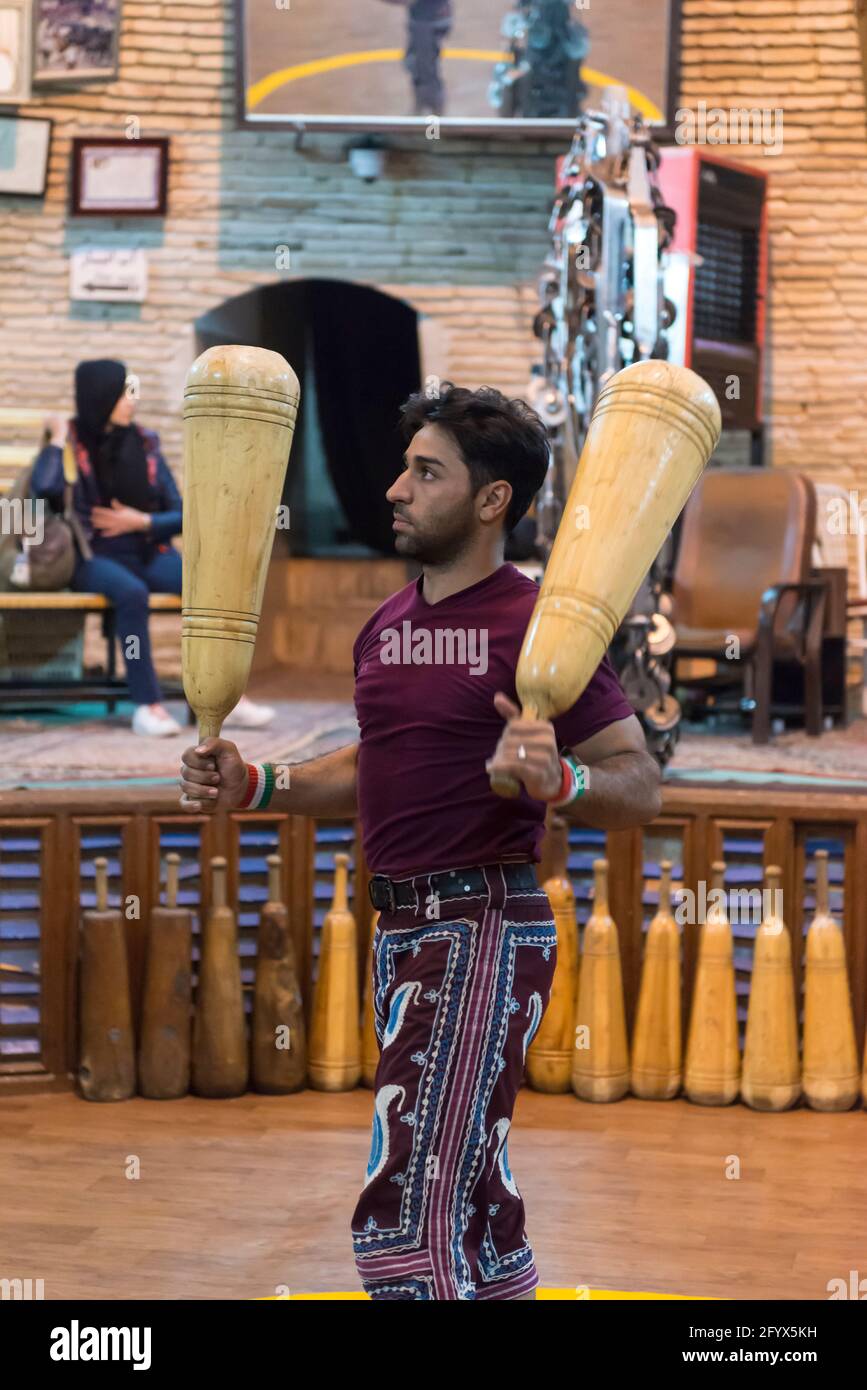 Sportif iranien faisant des exercices avec des clubs en bois lors d'un entraînement traditionnel dans un zourkhaneh (Maison de la force) à Yazd, province de Yazd, Iran. Banque D'Images