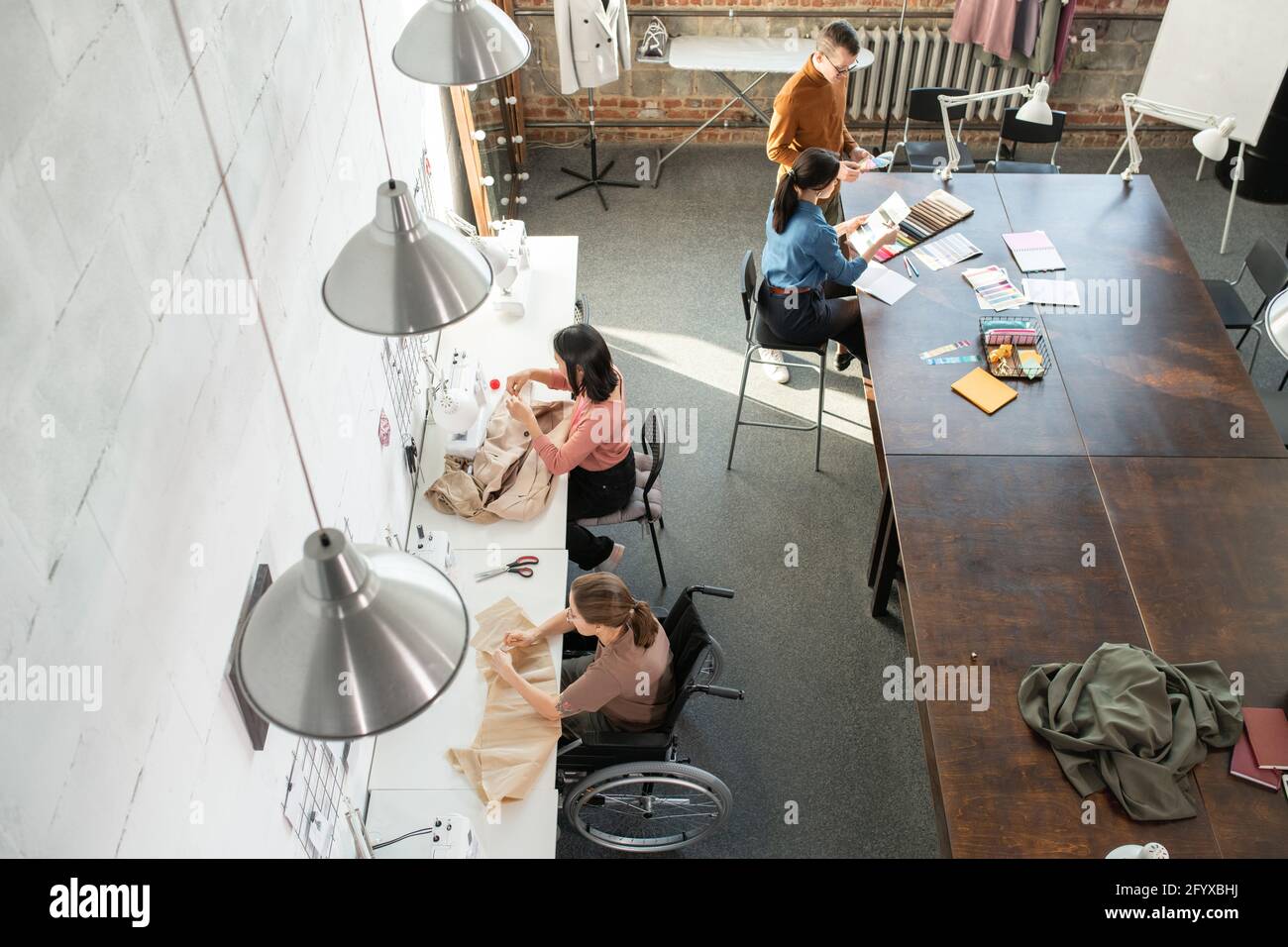 Tailleurs contemporains et créateurs de mode créatifs travaillant en petits groupes Banque D'Images