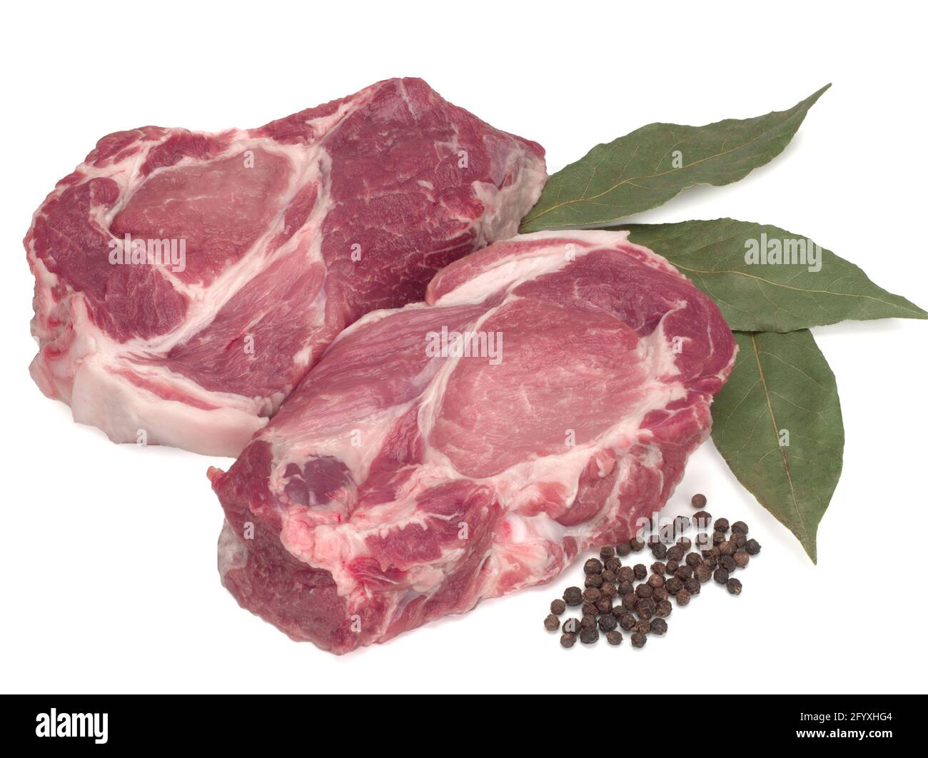 Deux coupes de viande de porc crue au poivre noir et feuilles de Laurier sur fond blanc Banque D'Images