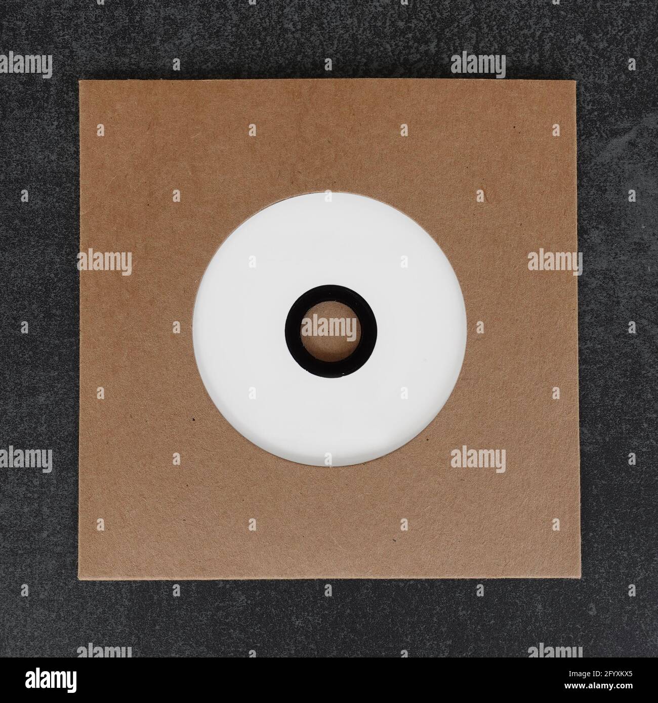 Disque compact cd vierge à étiquette blanche dans une housse en carton brun découpé. Élément de conception avec espace de copie pour votre photo et votre texte. Banque D'Images