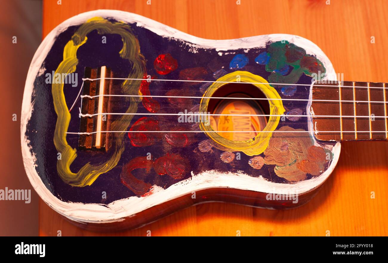 Un ukulele bleu peint à la main avec des couleurs blanc jaune rouge bleu  Photo Stock - Alamy