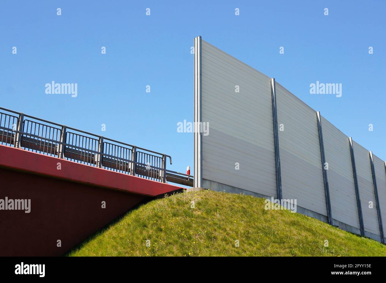 Photo d'une barrière de route élevée à l'angle bas une colline couverte d'herbe Banque D'Images