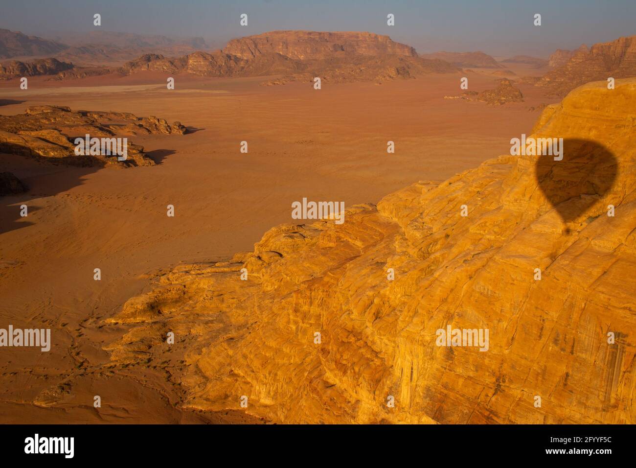 Vue sur le désert de Wadi Rum depuis un ballon d'air chaud au lever du soleil, avec l'ombre de ce ballon vu sur l'une des formations rocheuses, Jordanie, avril 2018 Banque D'Images