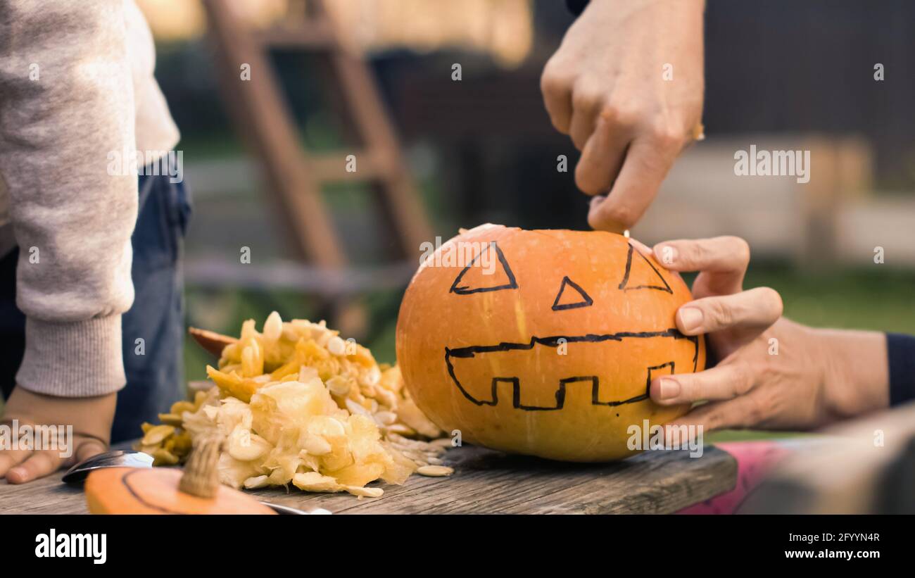 Des citrouilles à découper pour halloween dans la cour. Activités amusantes en famille. Banque D'Images