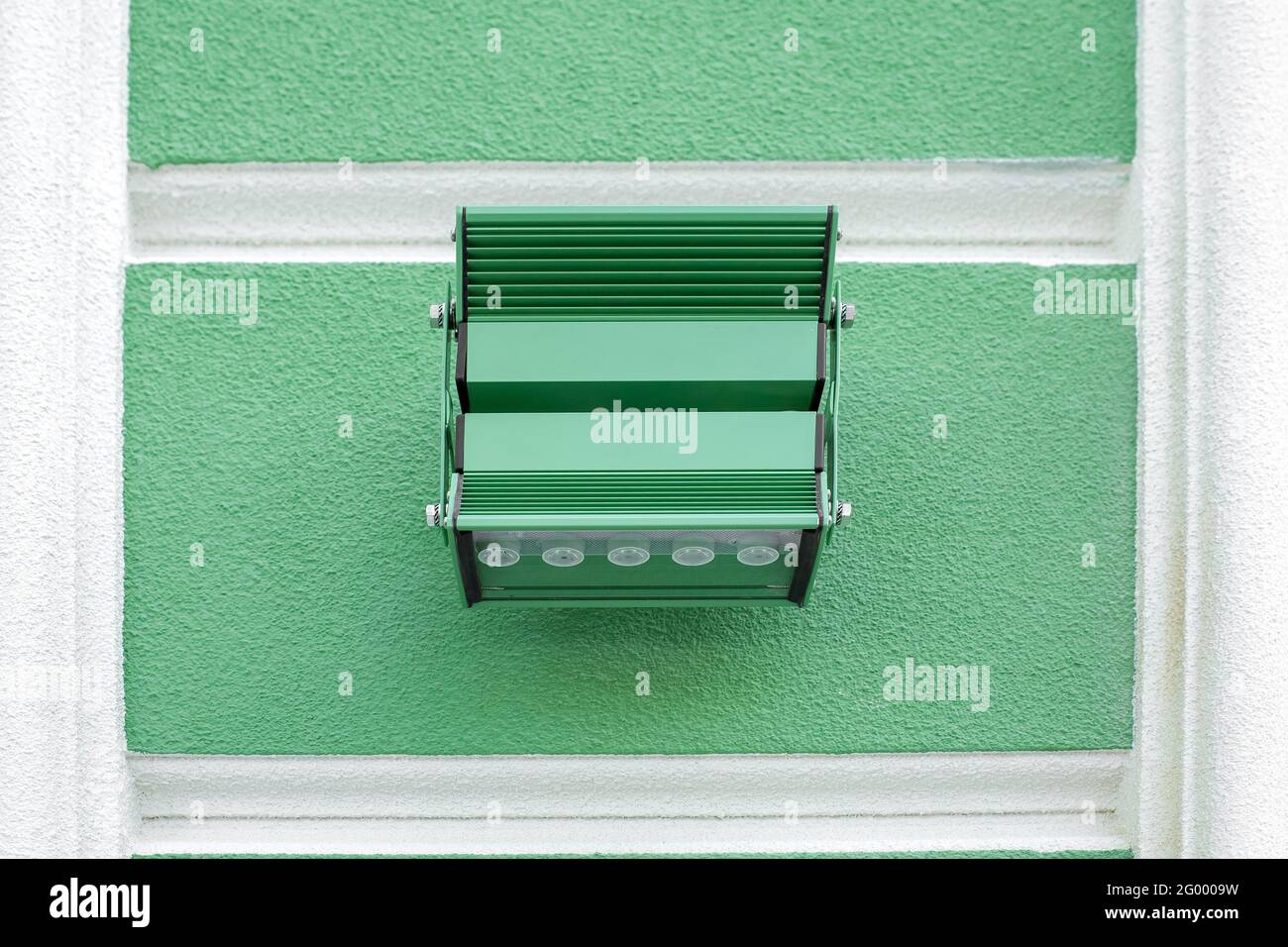 lanterne en fer avec diodes led pour l'éclairage de la façade du bâtiment. Rustication architecturale de couleur verte avec cadres blancs, gros plan Banque D'Images