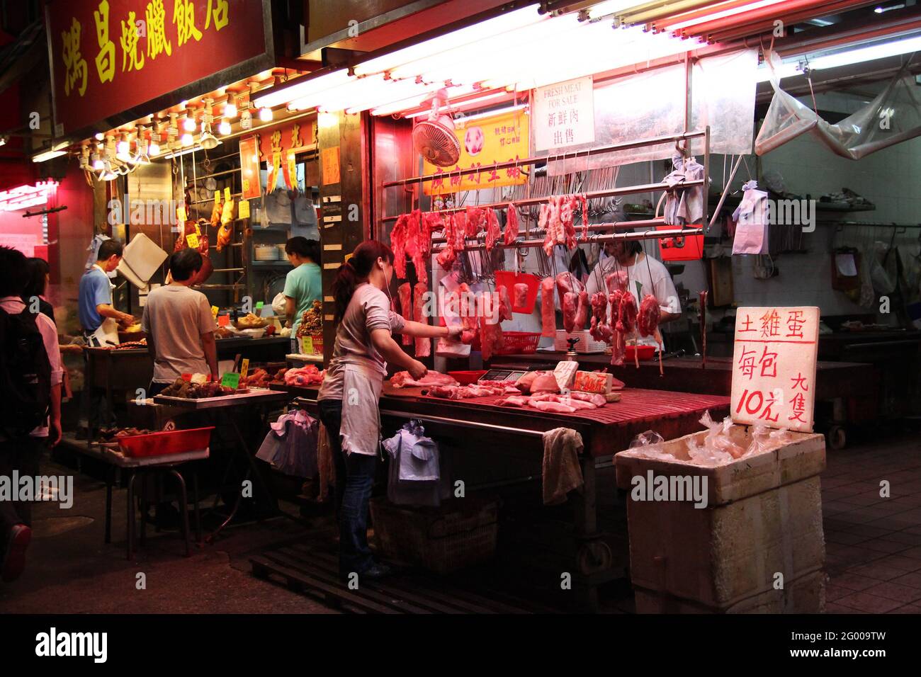 HONG KONG - APR. 14 2011: Boucherie vendant de la viande crue et des aliments cuits vendeur vendant du porc rôti et du poulet les uns aux autres à Fa Yuen Street M. Banque D'Images
