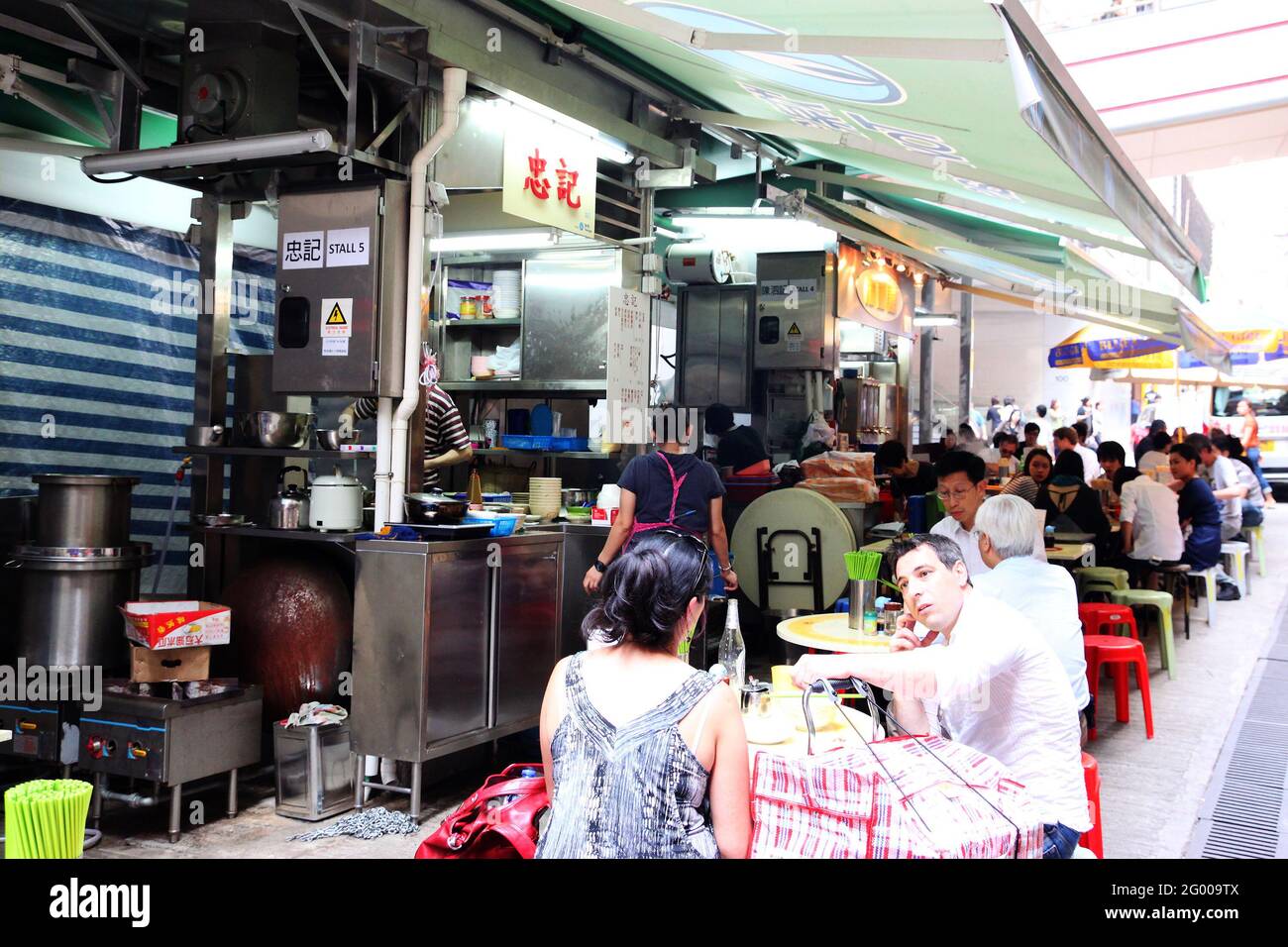 HONG KONG - APR. 19, 2011: La foule de l'heure du déjeuner manger dans les stands de nourriture de rue en plein air connu sous le nom de Dai Pai Dong dans le centre de Hong Kong. Ces cuisines extérieures le sont Banque D'Images