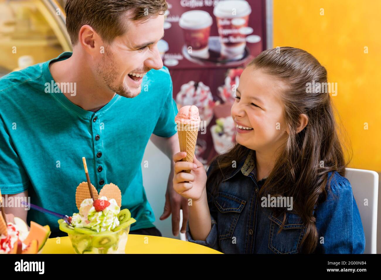 Papa et fille mangent de la glace avec beaucoup de plaisir Banque D'Images