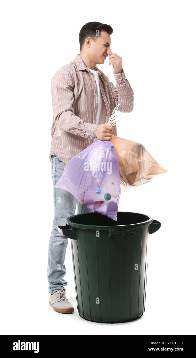 Un jeune homme jette des ordures dans la poubelle sur fond blanc Photo  Stock - Alamy
