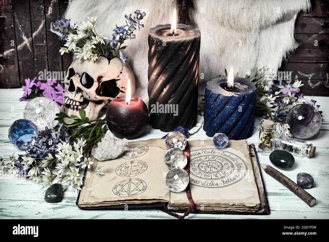 Encore la vie avec un livre ouvert avec des vacances wiccan et des symboles, le cristal et les bougies allumées. Arrière-plan ésotérique, gothique et occulte, Halloween mystique et Banque D'Images