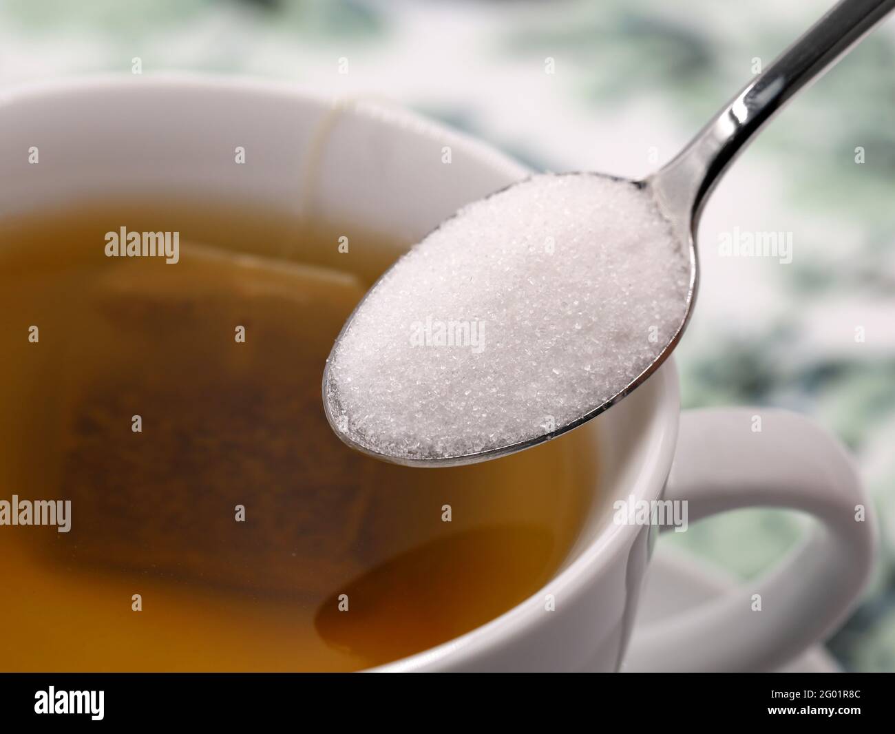 gros plan de la cuillère argentée avec du sucre blanc sur du thé cuvette Banque D'Images