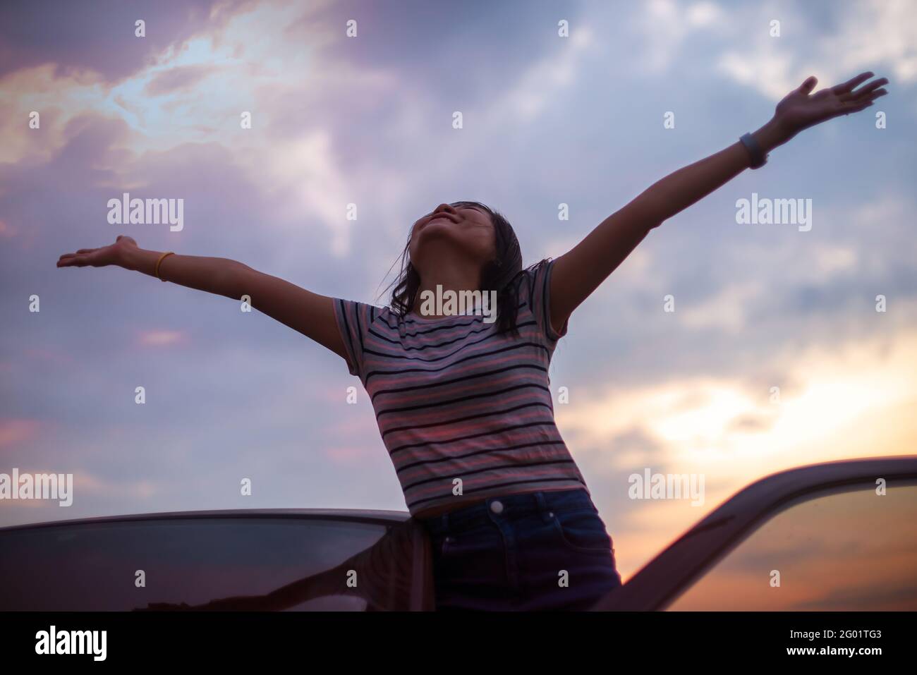 Liberté une femme asiatique se sentant libre a levé les mains au sommet avec le coucher de soleil en arrière-plan Banque D'Images
