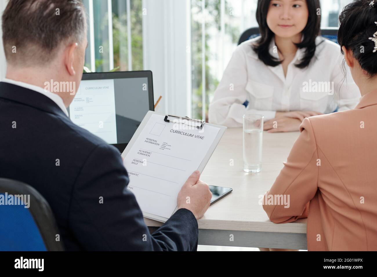 PDG de la société ou responsable des ressources humaines qui étudie le cv de jeune femme requérante Banque D'Images