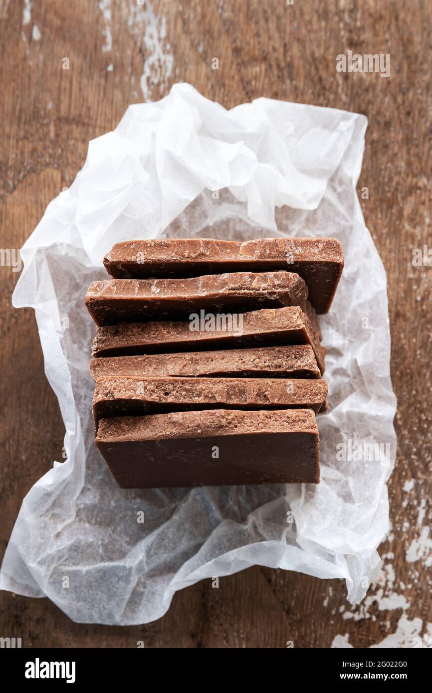 Morceaux de chocolat au lait sur fond de bois rustique Banque D'Images