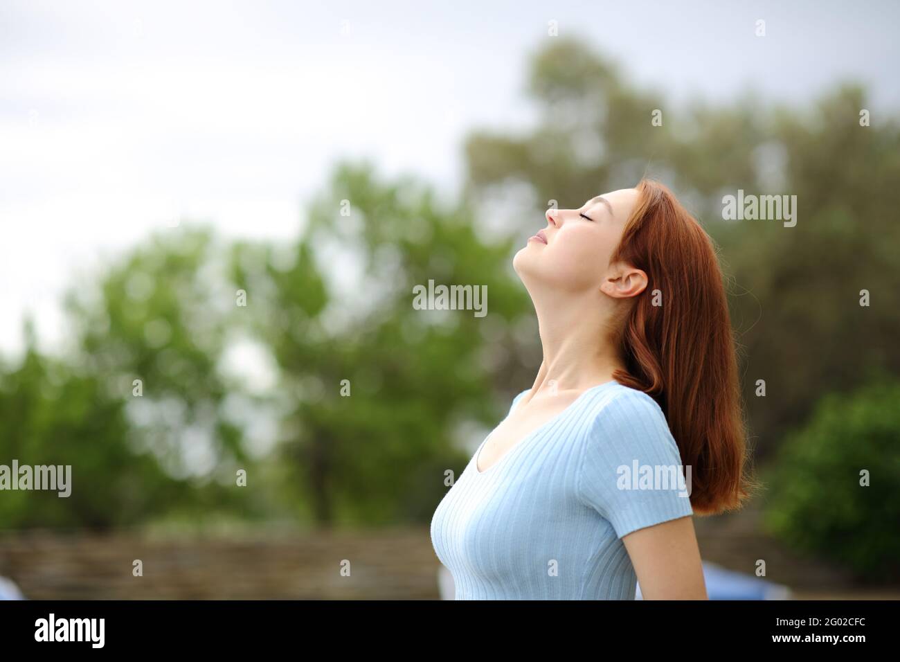 Profil d'une femme heureuse respirant de l'air frais dans un jardin Banque D'Images