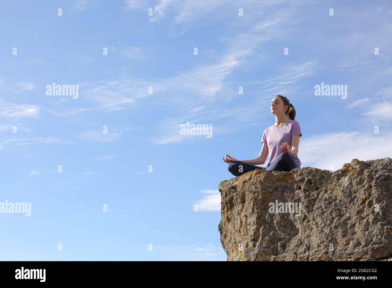 Yogi pratiquant le yoga lotus poser au sommet d'un falaise Banque D'Images