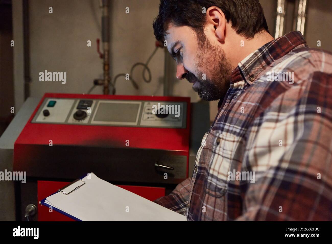 Installateur de chauffage avec liste de contrôle pour l'entretien du chauffage au gaz dans la chaufferie Banque D'Images