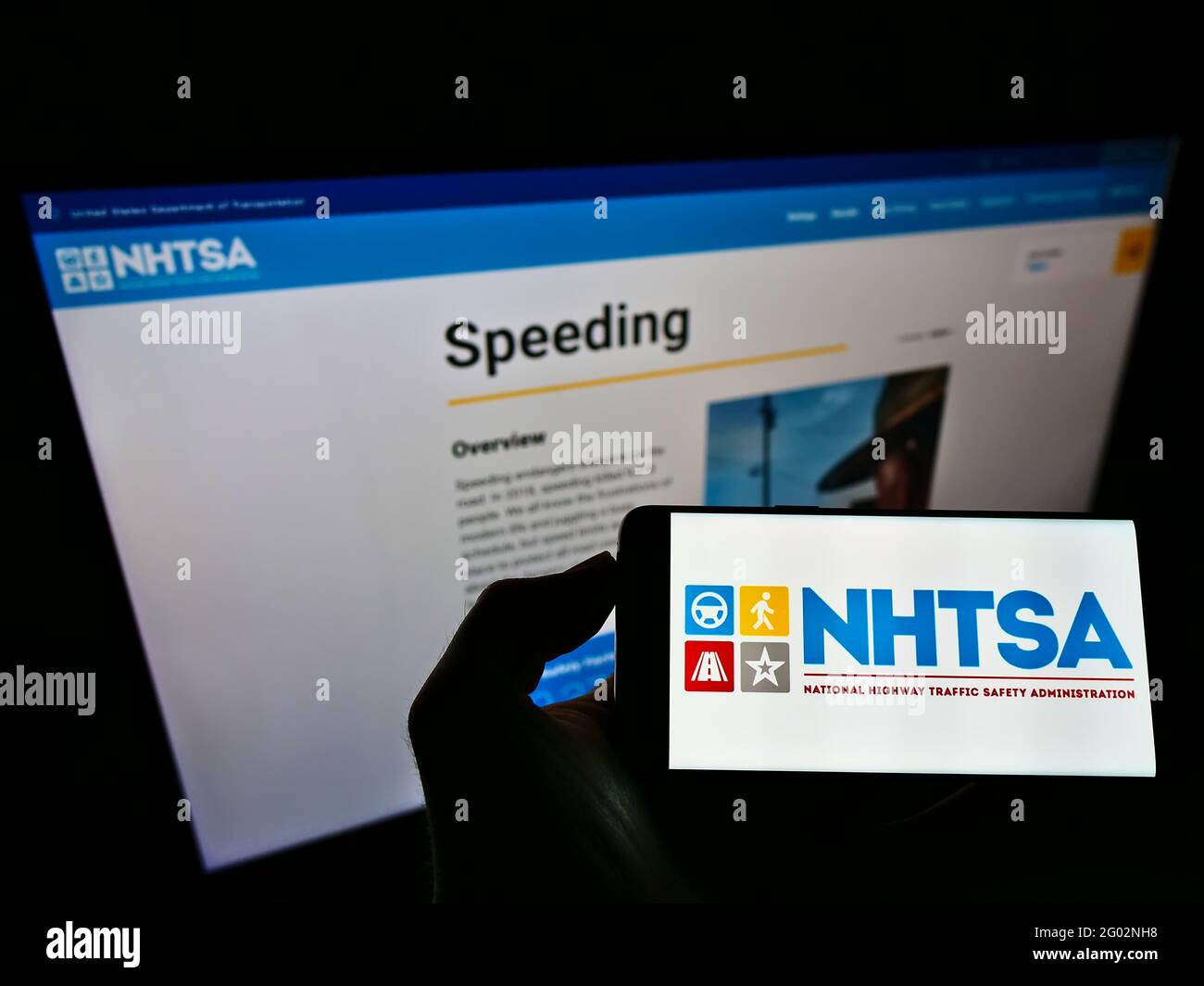 Personne tenant un téléphone mobile avec le logo de la National Highway Traffic Safety Administration (NHTSA) à l'écran avec une page Web. Mise au point sur l'affichage du téléphone. Banque D'Images