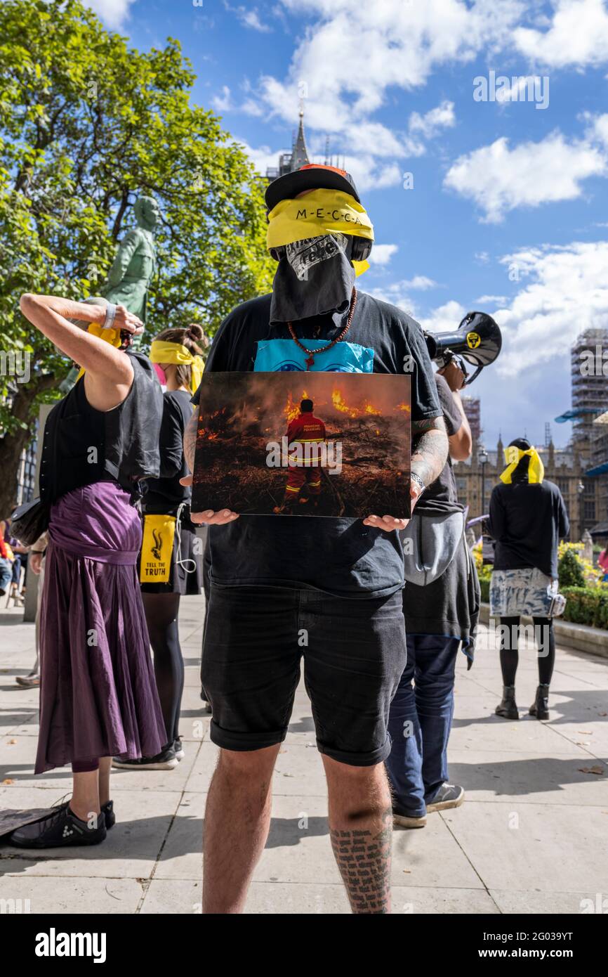 LONDRES, Royaume-Uni – Circa septembre 2020 : les manifestants de la rébellion de l'extinction tiennent des images des catastrophes naturelles causées par le changement climatique au cours d'une manifestation Banque D'Images