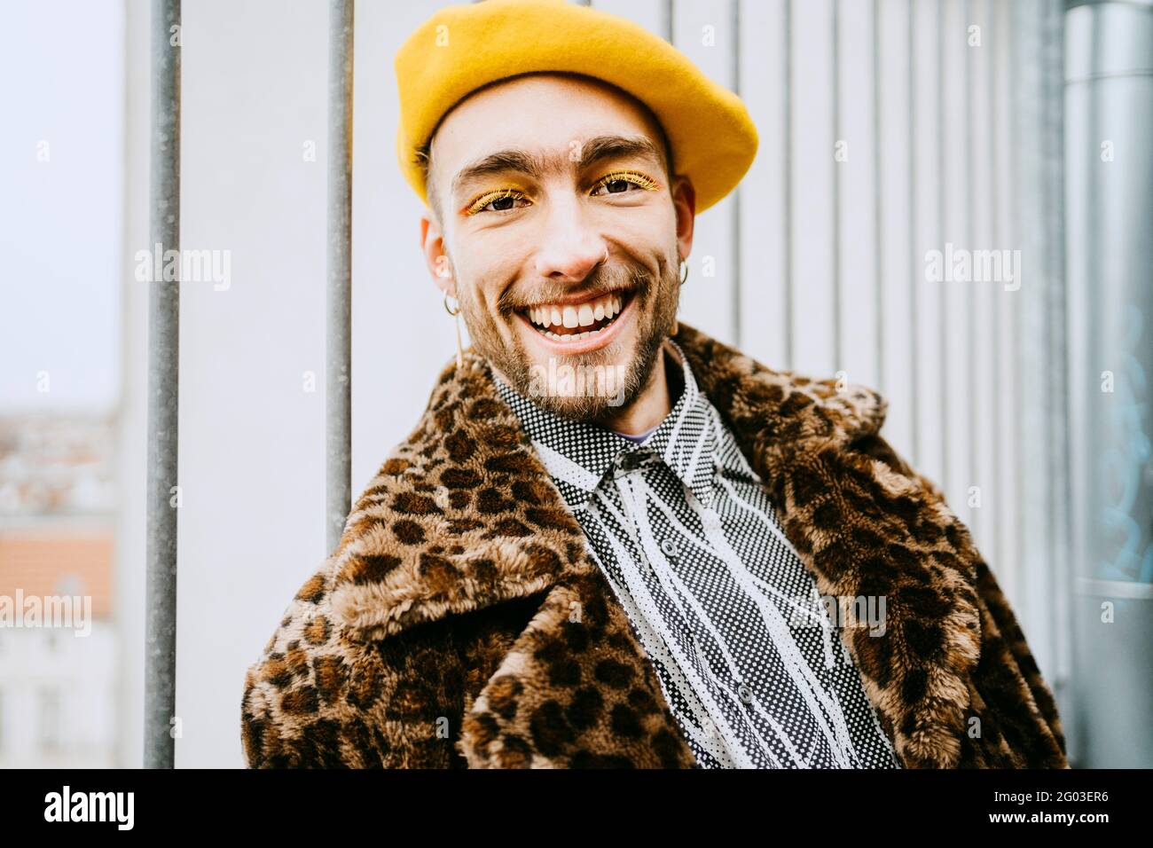 Portrait d'un jeune homme souriant portant un manteau à imprimé léopard Banque D'Images