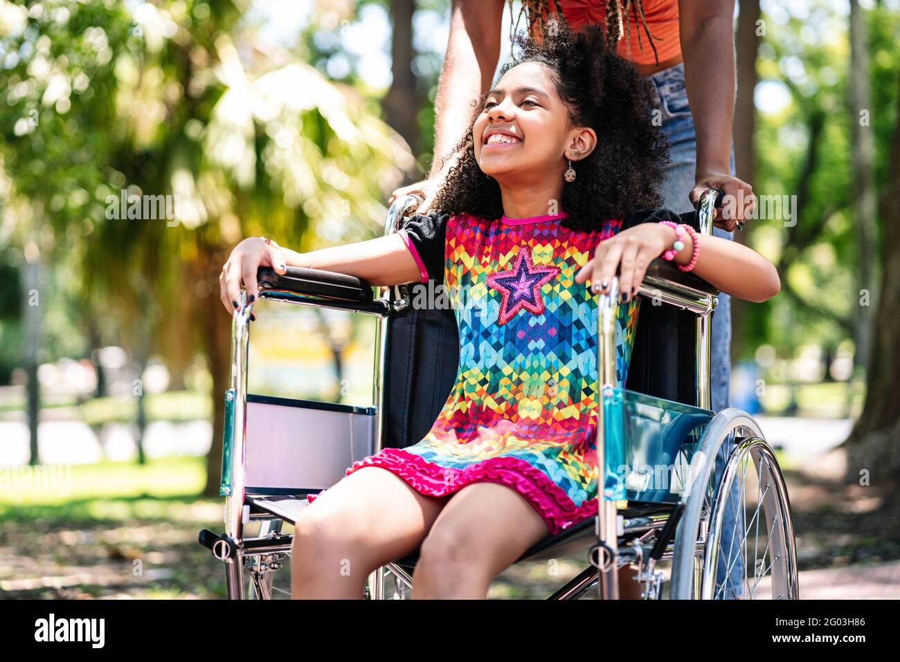 Petite fille en fauteuil roulant au parc avec sa mère. Banque D'Images