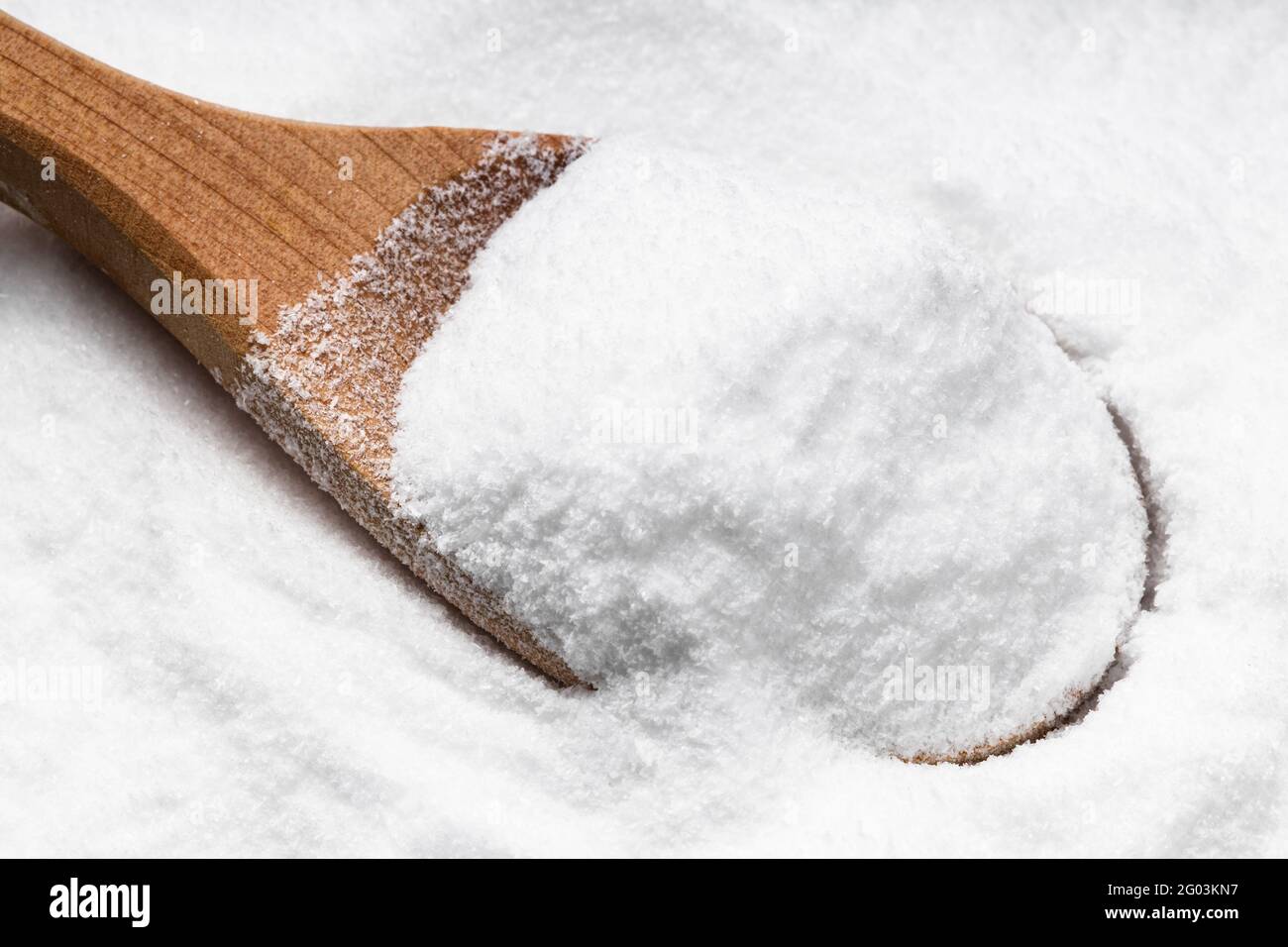 au-dessus de la vue de la cuillère en bois avec du sucre dextrose sur pile de sucre Banque D'Images