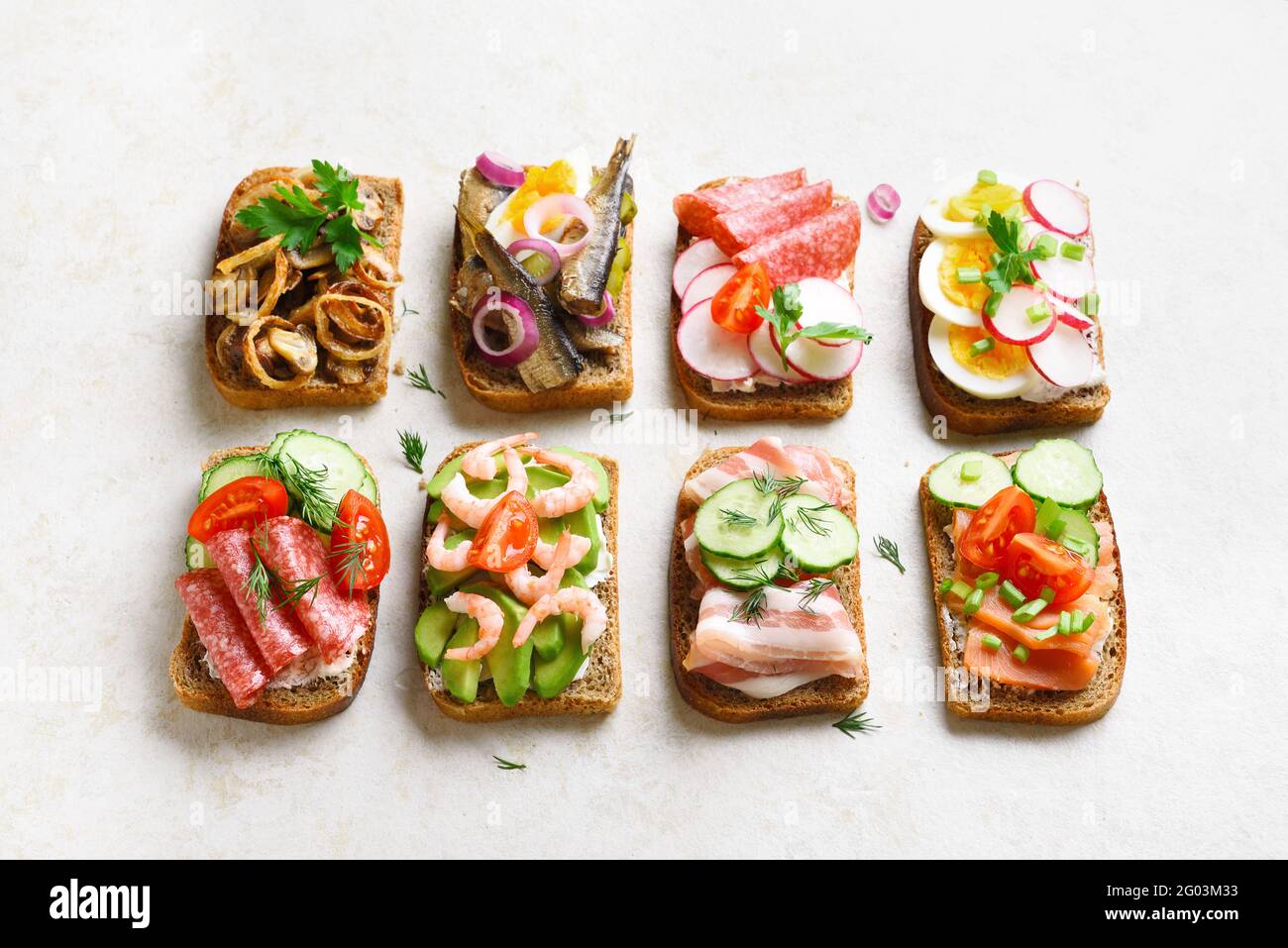 Ensemble de différents sandwichs avec viande, légumes et fruits de mer sur fond de pierre légère. En-cas savoureux et sains. Banque D'Images