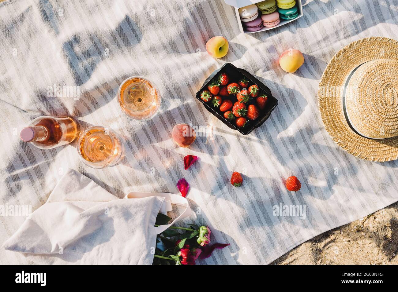 Vin de rose, pêches et fraises sur la plage. Banque D'Images