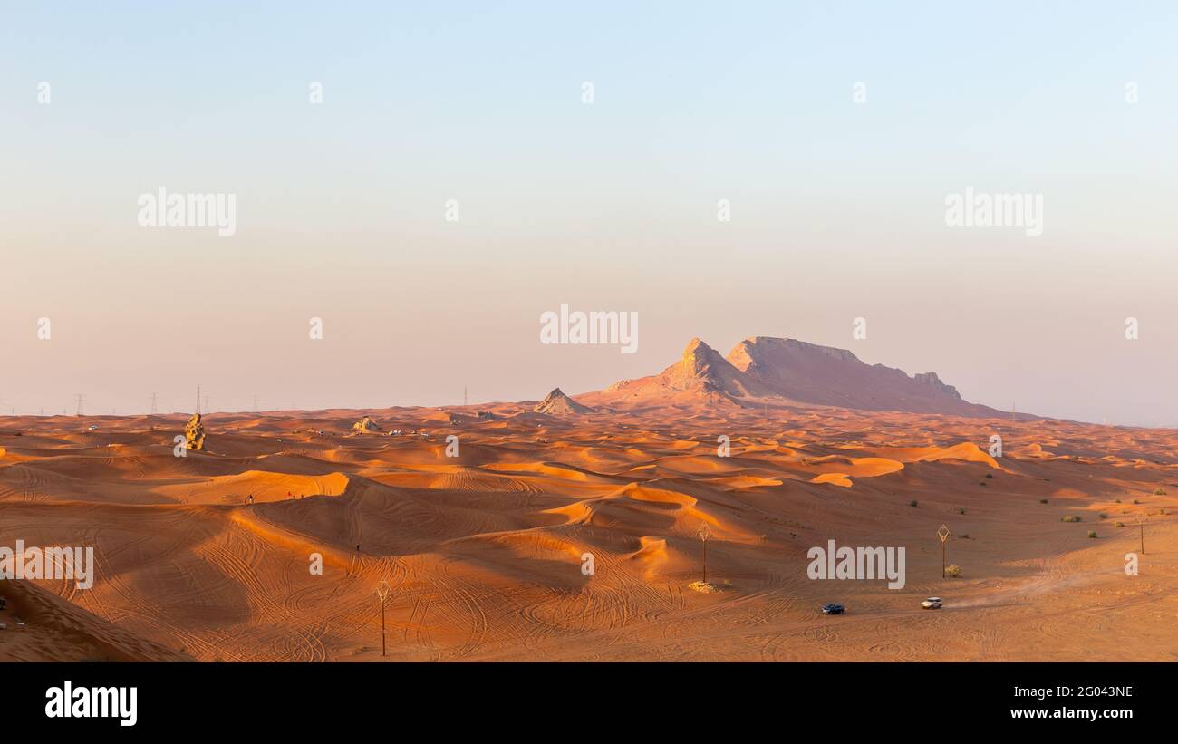 Panorama du coucher de soleil sur la crête de la montagne Fossil Rock et les dunes dorées du désert, Sharjah, Émirats arabes Unis. Banque D'Images