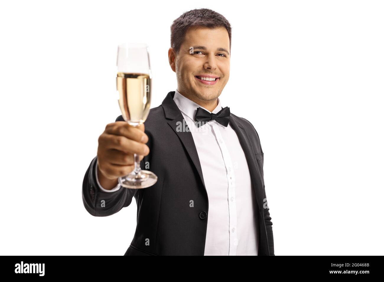Jeune homme élégant en costume et noeud toasting avec un verre de vin mousseux isolé sur fond blanc Banque D'Images