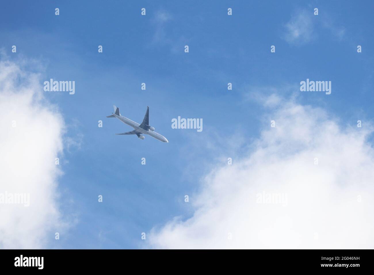 Avion volant dans un ciel bleu sur fond de nuages blancs. Concept d'avion commercial à deux moteurs, de turbulence et de déplacement Banque D'Images