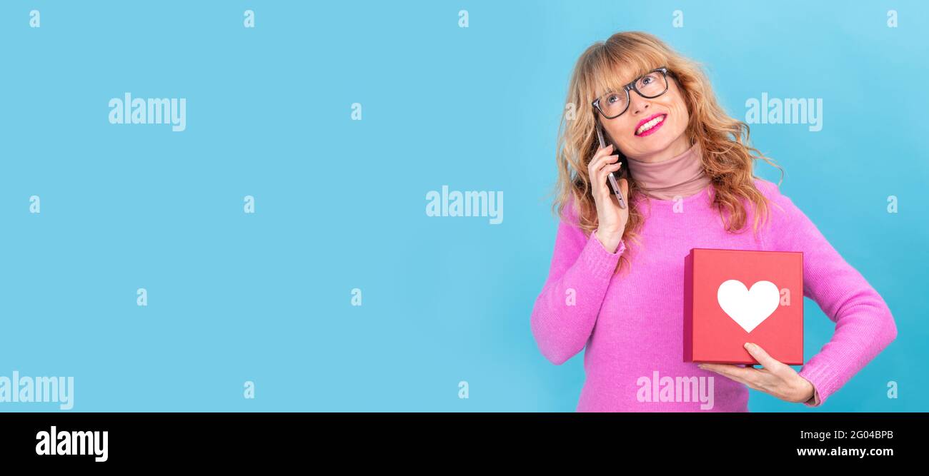 femme avec téléphone portable et boîte cadeau avec coeur isolé Banque D'Images