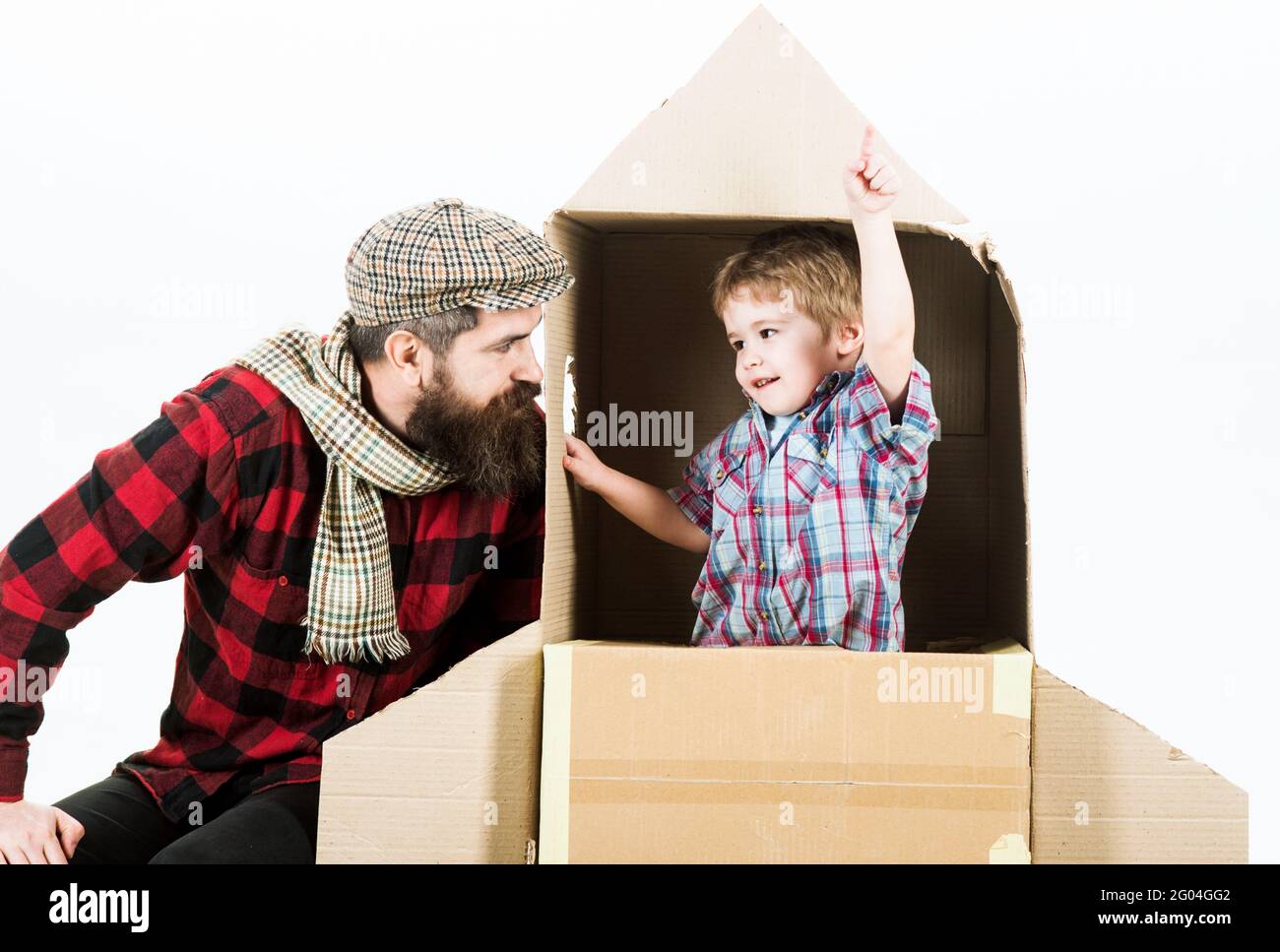 Fête des pères. Planification familiale. Papa et fils jouant avec une roquette en carton. Le rêve de l'enfant. Mignon garçon jouant cosmonaute. Banque D'Images