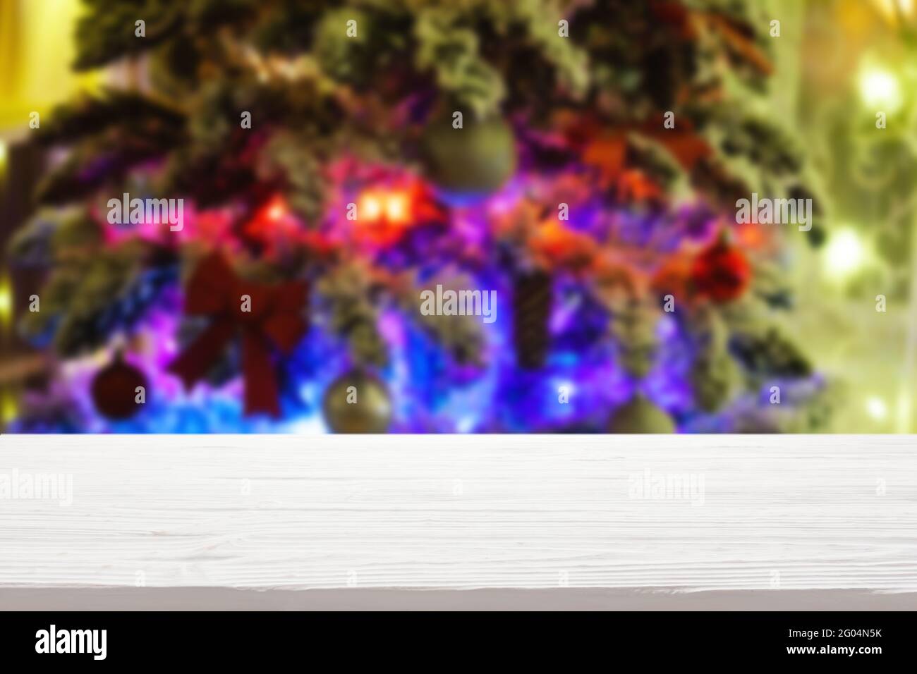 plateau de table en bois blanc sur un arbre de noël flou avec guirlandes arrière-plan Banque D'Images