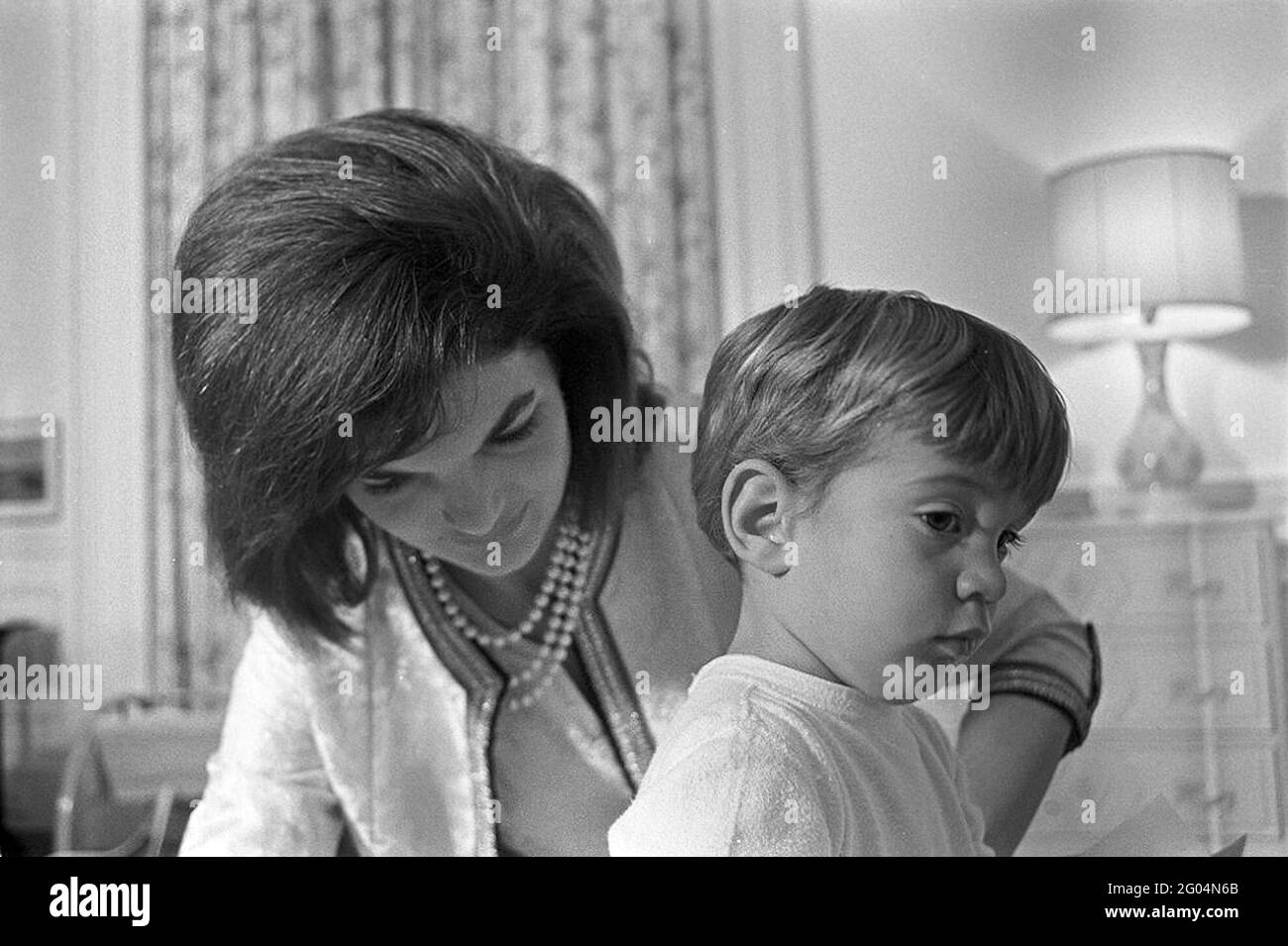 La première dame Jacqueline Kennedy siège avec son fils John F. Kennedy, Jr., à la garderie de John, à la suite d'une fête d'anniversaire conjointe pour lui et sa sœur, Caroline Kennedy. White House, Washington, D.C. Banque D'Images